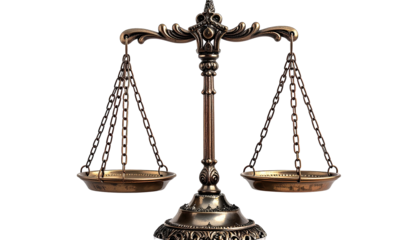 Antique metal balance scale with two pans against dark background