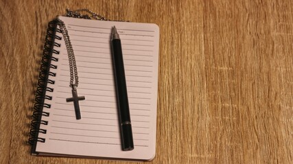 Prayer Journal with Cross Necklace and Pen on Wooden Table, Faith and Writing Concept