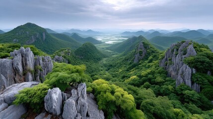 Lush Green Karst Mountains Under a Cloudy Sky with Jagged Rocky Outcrops in the Foreground and Distant Waterways