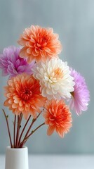 Macro photograph of a bouquet of pastel chrysanthemums in vibrant orange white and purple hues with delicate petals and soft natural lighting in a white vase against a blurred cool gray background
