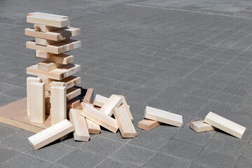 Large wooden blocks against a gray tile background. Wooden block tower. Business concept.