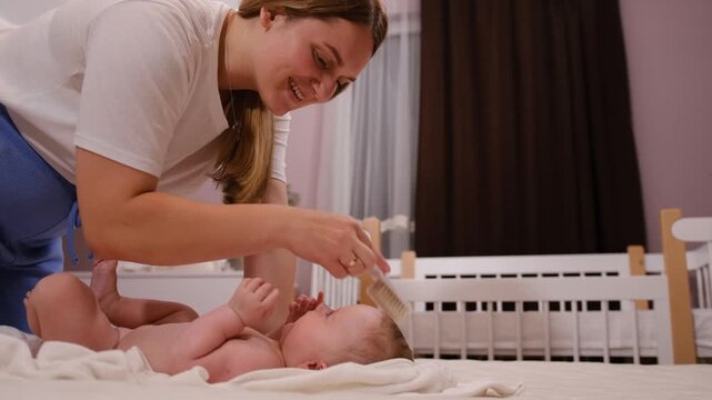 A portrait of a small child being scratched on the head with a brush. Combing the hair of a newborn baby. Hygiene and human care. Children's look.