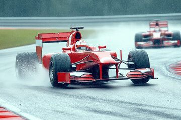 Formula 1 racing red car rushes along the race track at high speed during the rain