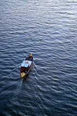 Tourist boat on the Douro River in Porto (Portugal) from a bird's eye view from above in evening light. The tours under the famous bridges are very popular with visitors. Seen from historic bridge.