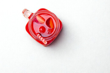 Red heart shaped jam jar with fruit slices on white background