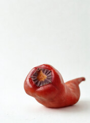 Unusual red fruit with radial patterned interior on white background
