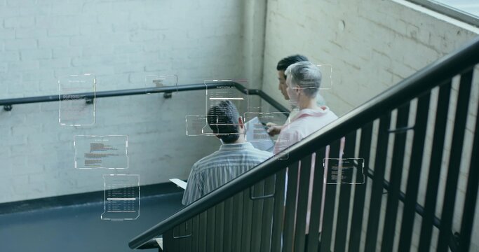Collaborating developers viewing digital code overlays in office stairwell with tablet and railing