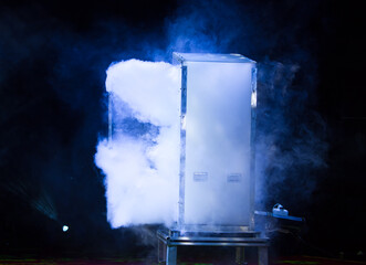 Smoke emerging from the stage box. Lights beams for showing presentation.