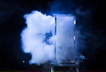 Smoke emerging from the stage box. Lights beams for showing presentation.