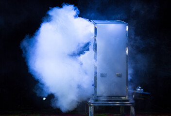 Smoke emerging from the stage box. Lights beams for showing presentation.