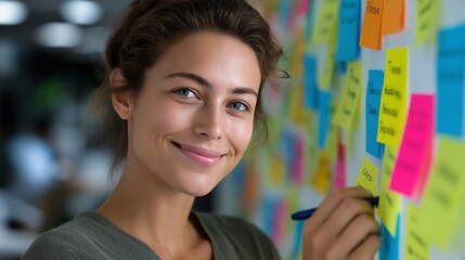 Young caucasian female adult writing ideas on colorful sticky notes with a smile