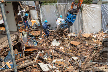 廃材・瓦礫を運ぶ作業員