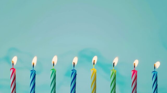 Set of colored birthday candles in a row on light pastel blue background. Celebration birthday cake colorful birthday candles