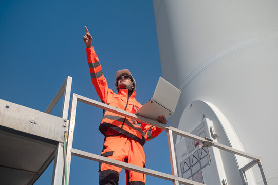Japanese wind turbine engineer with laptop working in windmill field