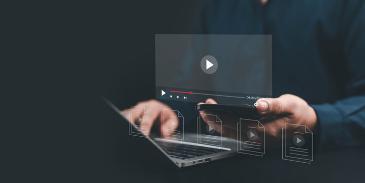 Businessman using laptop and smartphone with digital video player interface, representing online streaming, multimedia, content marketing, digital communication, technology, and modern business
