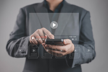 Businessman using smartphone with virtual video player interface, representing online streaming, media marketing, digital content, technology, communication, innovation, and modern multimedia business