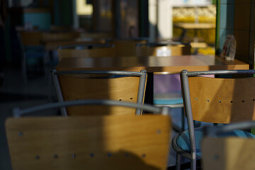 Empty café chairs bathed in warm afternoon light, capturing a quiet moment of stillness and everyday beauty in a modern urban setting.