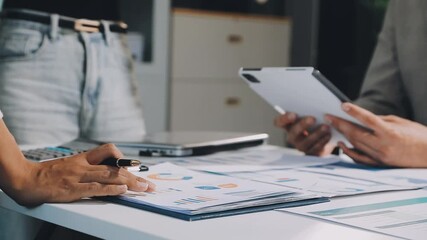 Financial analysts analyze business financial reports on a digital tablet planning investment project during a discussion at a meeting of corporate showing the results of their successful teamwork. - Powered by Adobe