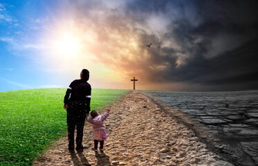 Young mother and her little daughter standing on the road to the cross