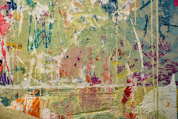 a textured, weathered wall with a chaotic mix of colors and textures.  The surface is heavily textured, showing signs of age and wear, with visible cracks and layers of paint