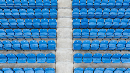 Symmetrical blue stadium seats from above, a serene geometric pattern of empty spaces