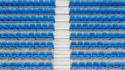 Symmetrical blue stadium seats from above, a serene geometric pattern of empty spaces