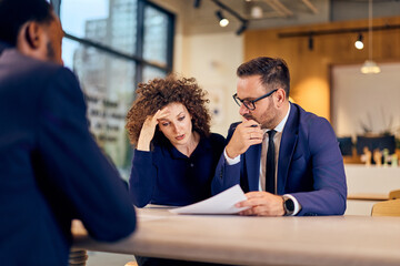 Business Meeting With Two Professionals Reviewing Documents At A Modern Office Space