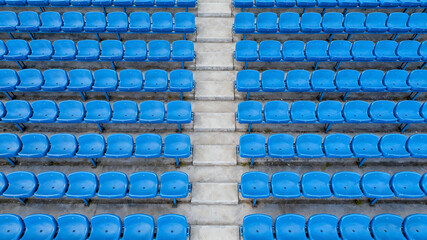 Symmetrical blue stadium seats from above, a serene geometric pattern of empty spaces