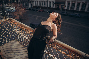 Woman tilting head back on balcony with city backdrop