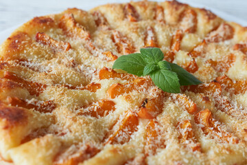A delicious apricot pie on a white wooden table, close-up. A delicious dessert.