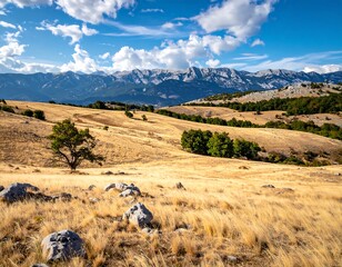 Sunny landscape of rolling hills, mountains, and a brilliant blue sky