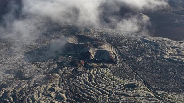 Aerial view of the vast volcano landscape with its unique rock formations, contrasted by the soft clouds above, Iceland.
