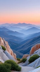 Serene Mountain Range Vista at Dawn with Hazy Blue Valleys and Soft Pink Sky Overlooking Rocky Outcrops and Greenery