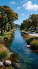 Scenic Riverbank With Lush Green Grass Tall Trees and Clear Blue Sky Over Rippling Water on a Sunny Day
