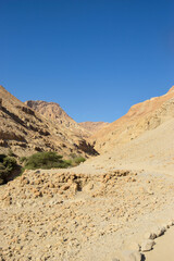 Desert landscape in the Judean Desert, Israel — rocky mountains under clear blue sky.