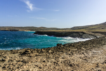 Where Caribbean Sea Meets Aruba’s Desert Coastline – Contrast of Turquoise Ocean and Arid Rocky Landscape Under Clear Blue Sky