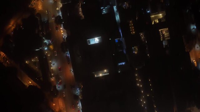 Overhead view showcasing lively urban streets of residential district in Lima, Peru, aglow with colorful night lights