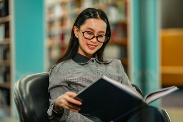Student relaxing with books after class in library, ideal for education marketing, back to school,...
