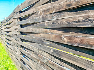 Wooden fence with unique diagonal slat design creating an inviting outdoor space near a lush green lawn