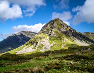Sunny landscape showcasing mountains, grassy fields, and a blue sky