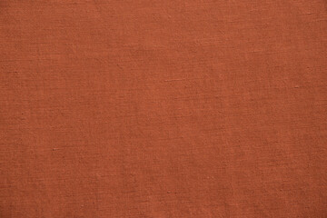 Close up view of burnt orange woven fabric. Quality linen textile texture ideal for backgrounds or design