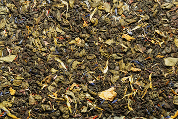 Top view green Ceylon tea with petals of different flowers.