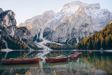 Scenic lake Bries surrounded by mountains with wooden boats in a serene alpine setting at dawn