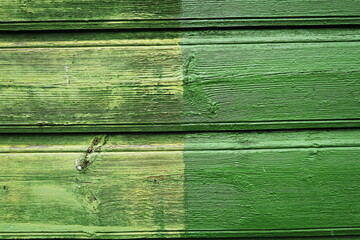 Planches de bois peintes en vert délavées. Détail de façade de maison en bois.