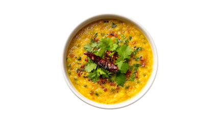 A top-down shot of a flavorful bowl of yellow lentil dal garnished with fresh cilantro a dried red chili and spices
