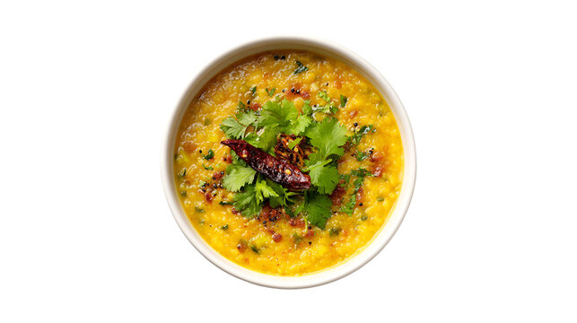 A top-down shot of a flavorful bowl of yellow lentil dal garnished with fresh cilantro a dried red chili and spices