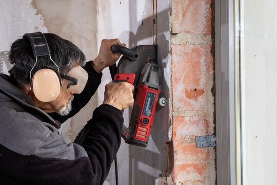 Construction Worker using a Wall Chaser to make Channels for Electric Installation