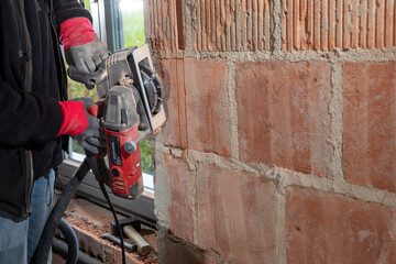 Construction Worker using a Wall Chaser to make Channels for Electric Installation