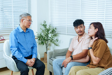 Obraz premium asian couple talking with senior male psychiatrist during therapy session in clinic discussing emotional issue marriage problem receiving relationship advice mental health support with calm listening