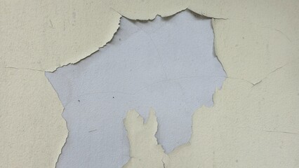 Old concrete wall painted yellow, peeling paint, scratches, dilapidated wall, wall has a cracked yellow surface of rough concrete.